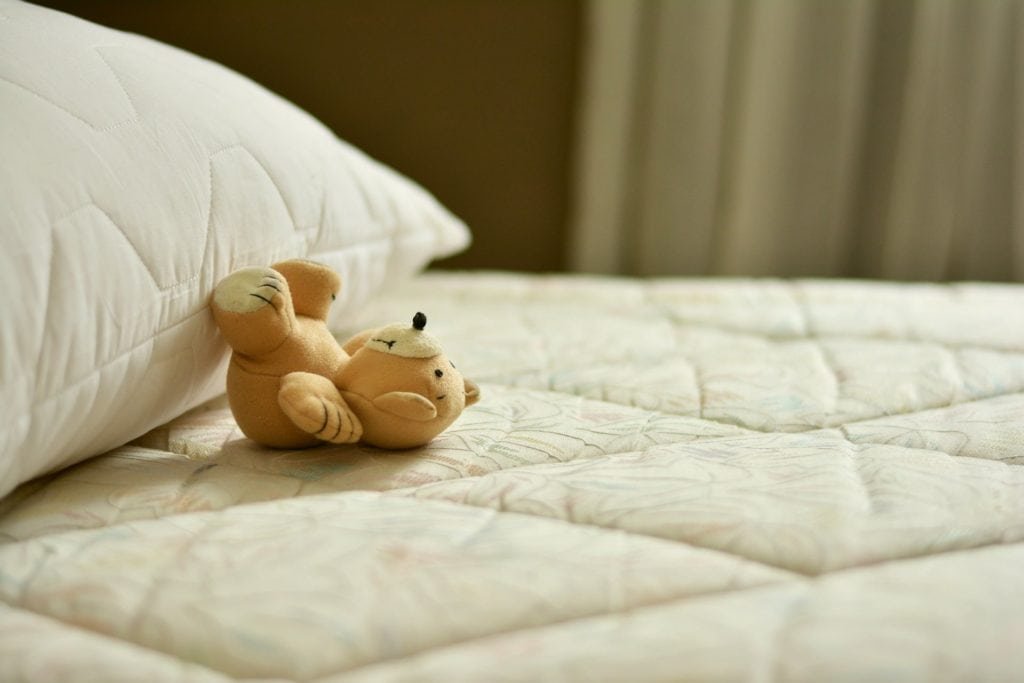 Ein Kaltschaummatratze-Teddybär auf einem Bett.